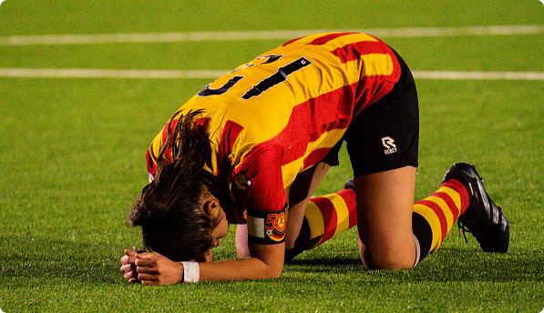 Football player kneeling on the pitch after a penalty match